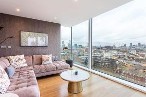 a living room with a couch and a large window at Stunning London View Flat in London