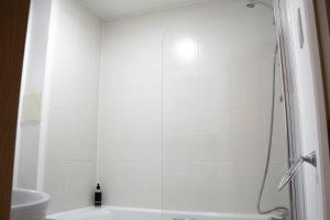 a white bathroom with a shower and a toilet at Modern Two Bedroom Apartment with Free Parking, Wifi & Sky TV by HP Accommodation in Milton Keynes