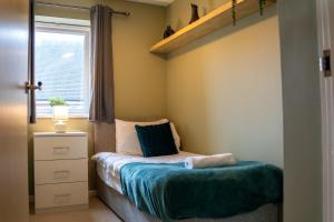 a small bedroom with a bed and a window at Modern Two Bedroom Apartment with Free Parking, Wifi & Sky TV by HP Accommodation in Milton Keynes