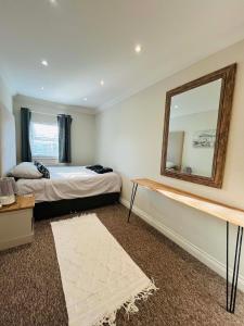 Un dormitorio con una cama y un espejo en la pared. en The Coastal Escape, en Bournemouth 10 fotos más