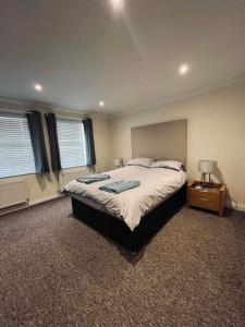um quarto com uma cama grande e uma mesa de cabeceira em The Coastal Escape em Bournemouth