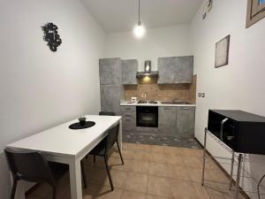 kuchnia z białym stołem i krzesłami w obiekcie Appartamento Lagrange - Torino Centro w Turynie