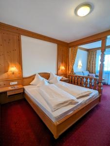 een slaapkamer met een groot bed in een kamer bij Hotel Heinz in Brunico