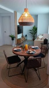 - un salon avec une table, des chaises et une lampe dans l'établissement Trotamundos, apartamento nuevo en el centro, à Cordoue