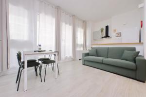 Una sala de estar con un sofá verde y una mesa. en Porta San Giovanni Suite, en Roma