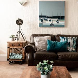 uma sala de estar com um sofá castanho e uma mesa em At Anchor (with a Harbour View) em Fife