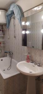 a bathroom with a sink and a mirror and a tub at Casa di Lucy in Frabosa Soprana