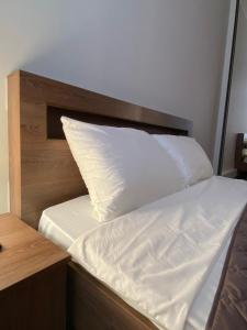 リヴィウにあるMini-loft on Rynok Squareのベッド(白いシーツ、木製ヘッドボード付)