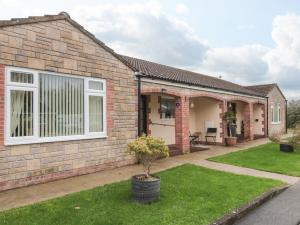 a brick house with a patio and grass at Russet in Bridgwater