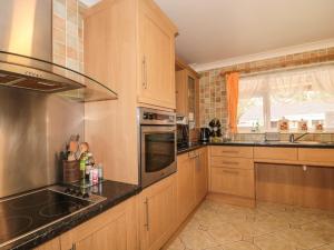 a kitchen with wooden cabinets and stainless steel appliances at Russet in Bridgwater