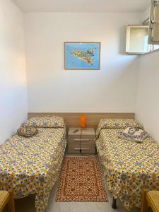 Zimmer mit 2 Betten und einer Kommode in der Unterkunft Acireale Centro in Acireale