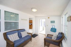 a living room with a blue couch and two chairs at Oceans 13 Unit A in Saint Augustine Beach
