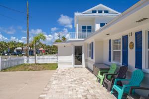 two chairs sitting outside of a white house at Oceans 13 Unit A in Saint Augustine Beach +42 photos