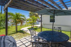 a table and chairs with an umbrella on a patio at Oceans 13 Unit A in Saint Augustine Beach