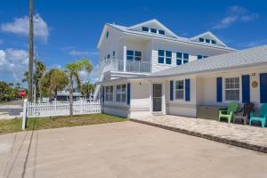 a white house with two chairs in front of it at Oceans 13 Unit A in Saint Augustine Beach