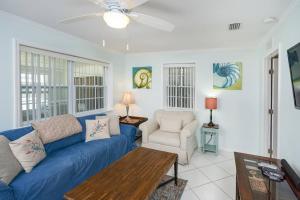 sala de estar con sofá azul y silla en Oceans 13 Unit A, en St. Augustine Beach