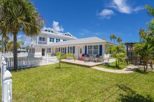 una casa blanca con una valla y un patio en Oceans 13 Unit A en St. Augustine Beach