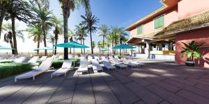 eine Reihe von Liegestühlen und Sonnenschirmen in einem Resort in der Unterkunft Margaritaville Beach Resort Ft Myers Beach in Fort Myers Beach