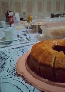 a table with a cake on a pink plate at Pousada Chalés Cantinho do Ronca - Paraty Mirim in Paraty +22 photos