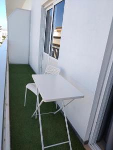 - Balcón con mesa blanca y 2 sillas en Apartamentos Bello Lanzarote, en Arrecife