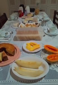 a long table with plates of food on it at Pousada Chalés Cantinho do Ronca - Paraty Mirim in Paraty