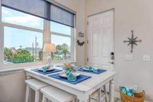 een eetkamer met een witte tafel en een raam bij Oceans 13 Condo C in Saint Augustine Beach