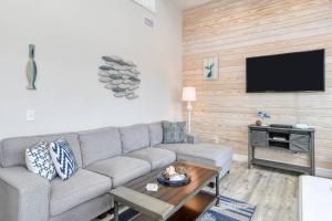a living room with a couch and a flat screen tv at Oceans 13 Condo C in Saint Augustine Beach