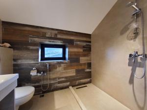 een badkamer met een toilet en een televisie aan de muur bij Lady and Bear GH 
