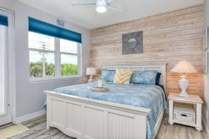 a bedroom with a bed with a wooden wall at Oceans 13 Condo C in Saint Augustine Beach