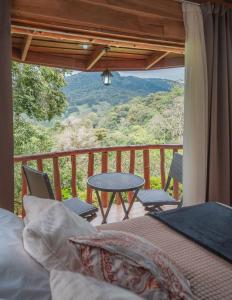 a bedroom with a balcony with a table and chairs at Cedrela Eco-Lodge & Restaurante in El Copey