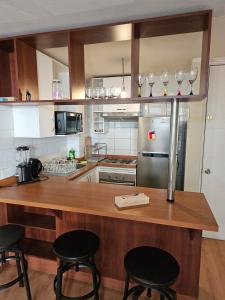 een keuken met een houten aanrecht met 3 krukken bij Bellavista ApartRent in Santiago