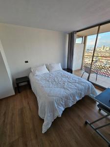 een slaapkamer met een groot bed en een balkon bij Bellavista ApartRent in Santiago