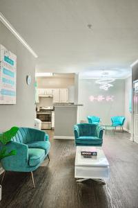 a living room with blue chairs and a kitchen at Heartbeat Of ATL- Gated Community, Pool, Gym, and much more! in Atlanta