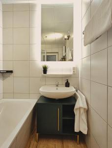 y baño con lavabo, bañera y espejo. en Modern & Comfortable Apartment Stuttgart - Netflix - 4K TV - waipu en Korntal-Münchingen