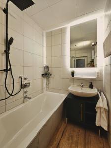 Baño blanco con bañera y lavamanos en Modern & Comfortable Apartment Stuttgart - Netflix - 4K TV - waipu en Korntal-Münchingen