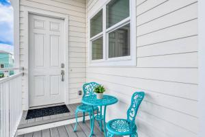 a table and two chairs on a porch with a door at Oceans 13 Condo D in Saint Augustine Beach