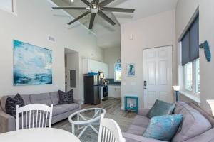 sala de estar con sofá y ventilador de techo en Oceans 13 Condo D, en St. Augustine Beach
