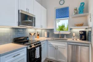 a kitchen with white cabinets and a stove top oven at Oceans 13 Condo D in Saint Augustine Beach +34 photos