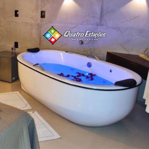 a white bath tub sitting in a bathroom at Pousada Quatro Estações in Gravatal