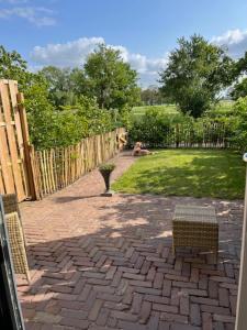 a brick patio with two chairs and a fence at De Citadel - de Weide in Markelo