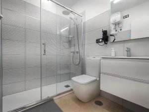 a bathroom with a shower and a toilet and a sink at Apartamentos Bello Lanzarote in Arrecife