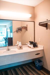 a bathroom with a sink and a large mirror at Super 8 by Wyndham Columbia/Ft. Jackson SC in Columbia