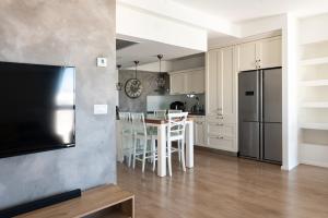 a kitchen with a table with chairs and a refrigerator at Jaffas Yard By IsrApart in Tel Aviv