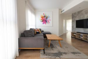 a living room with a couch and a table at Seaside Court Retreat By IsrApart in Tel Aviv