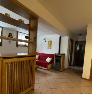 una sala de estar con un sofá rojo en una habitación en Ciasa de Milu, en Cibiana