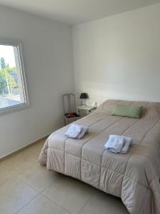 - une chambre avec un grand lit et 2 serviettes dans l'établissement Las flores, Depto Con Cochera, à Neuquén