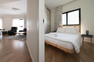 a bedroom with a bed and a living room at Seaside Court Retreat By IsrApart in Tel Aviv