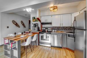a kitchen with white cabinets and stainless steel appliances at Mountain Green Condo 3F1 condo in Killington