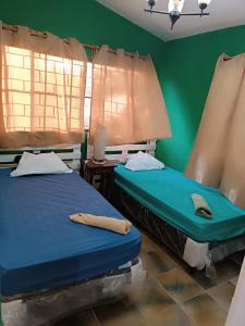 twee bedden in een kamer met groene muren bij Quinta El Espino in Ahuachapán