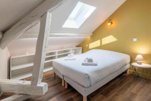 um quarto com uma cama branca e uma clarabóia em Villa des Cygnes près du lac marina Grand Port em Aix-les-Bains